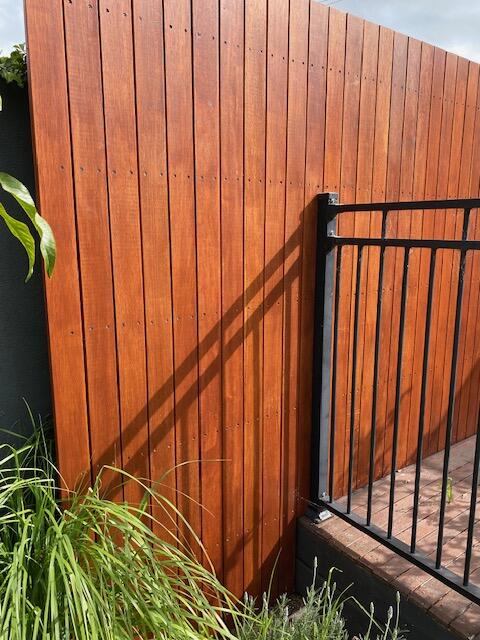 Picture of a timber boundary fence intersecting with a pool fence